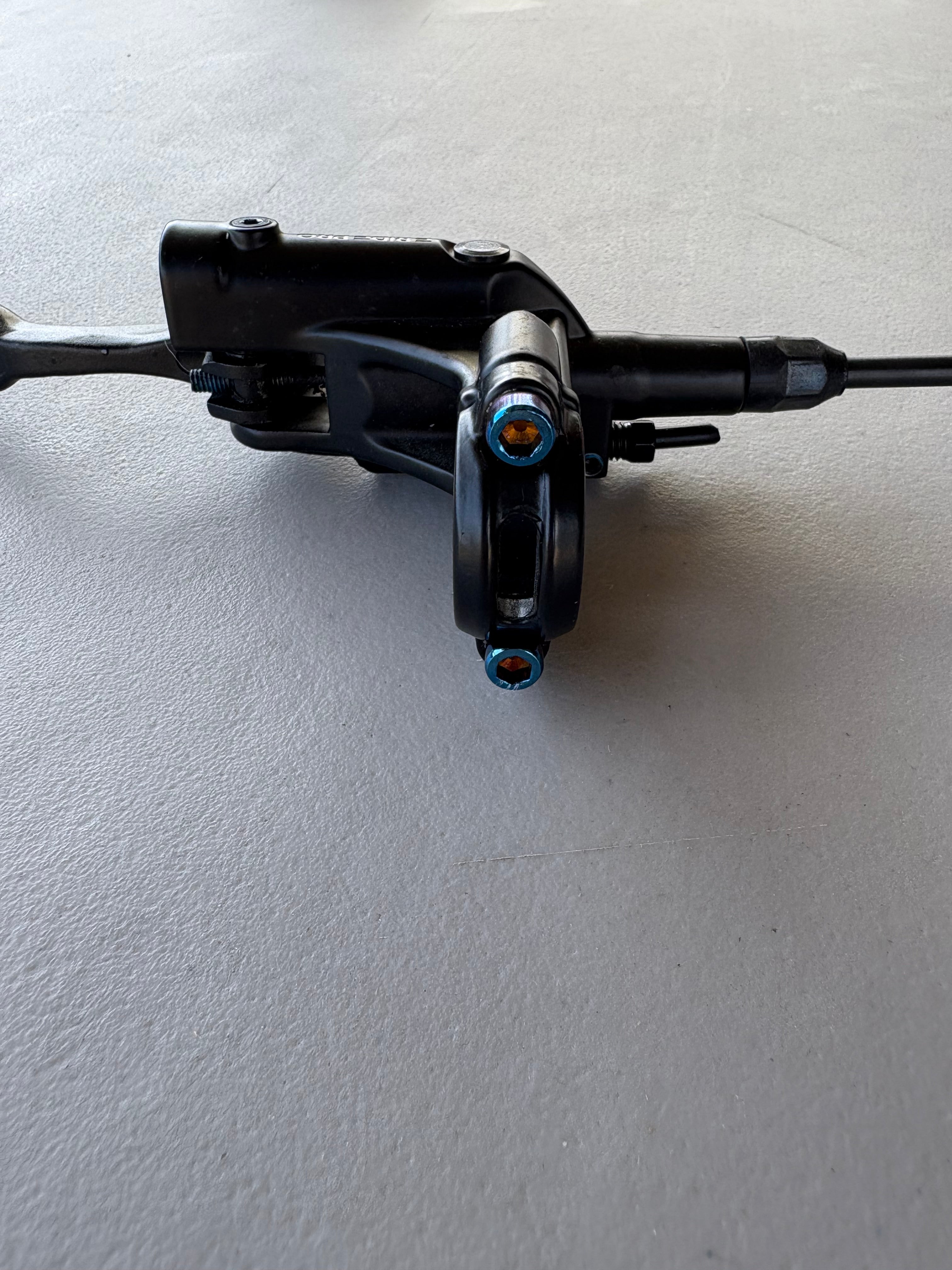 Titanium brake mount bolts installed on an e-moto brake caliper