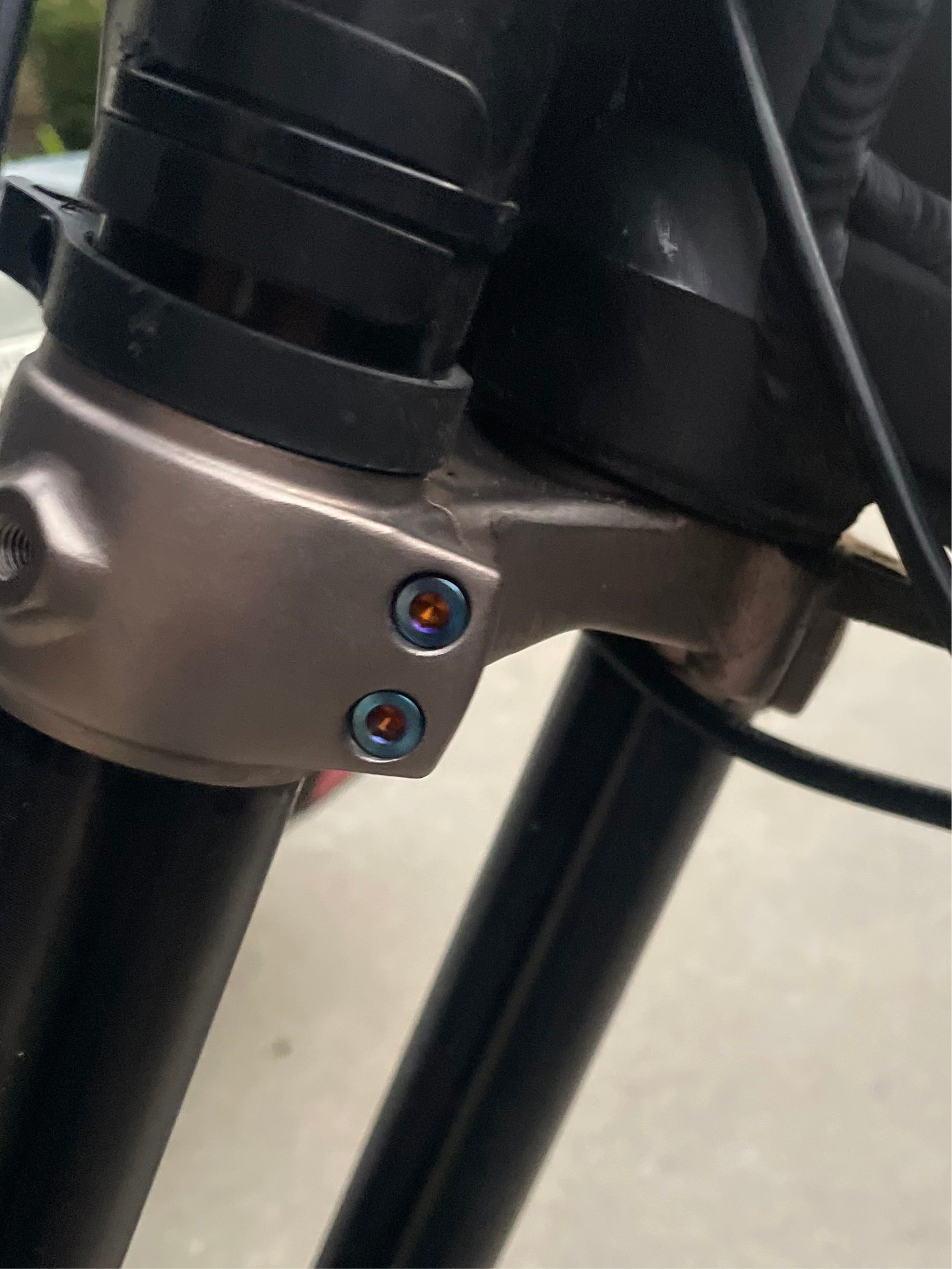 Titanium triple clamp bolts close-up showing machined finish
