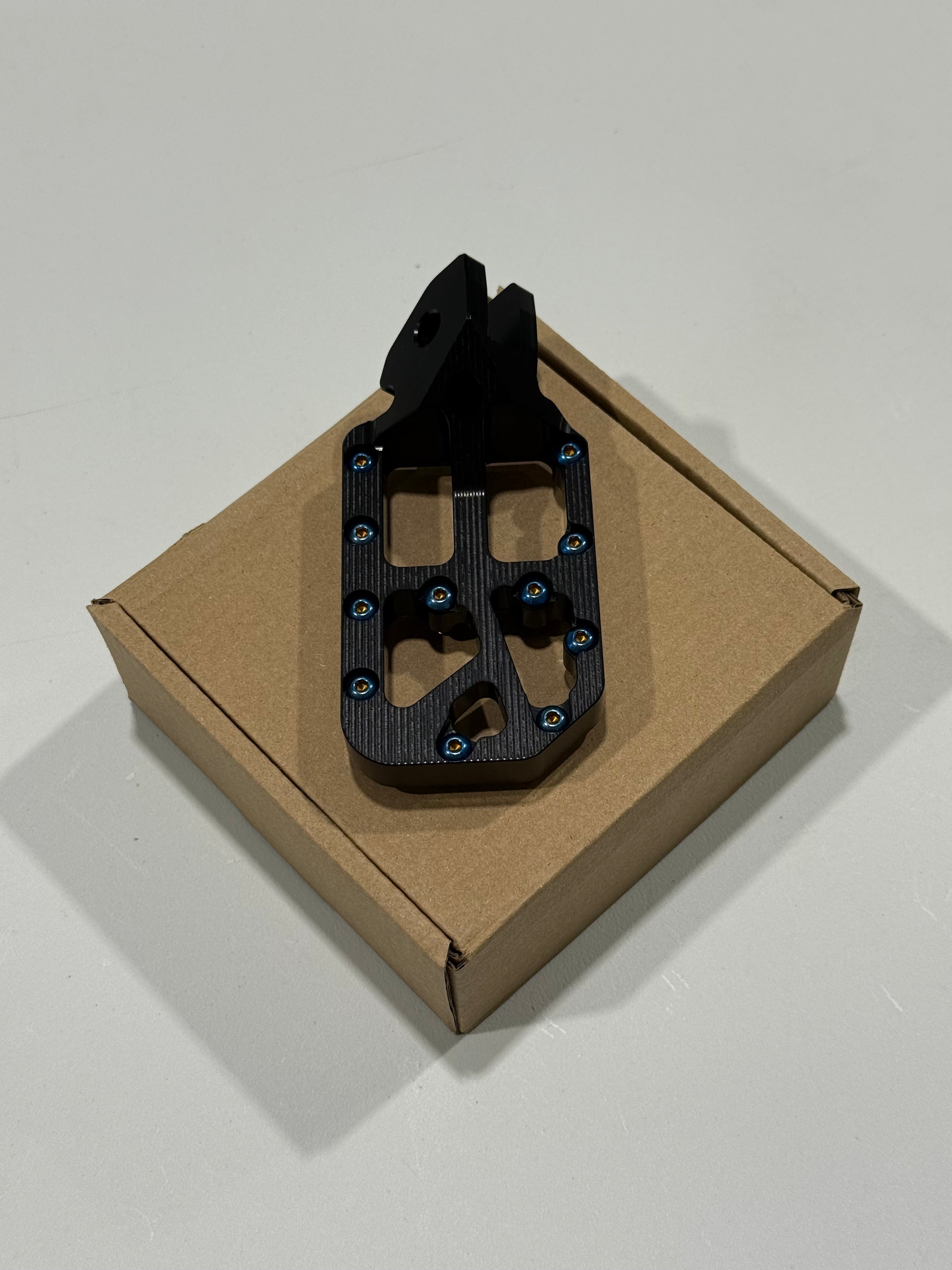 Wide foot pegs full kit laid out for e-moto install