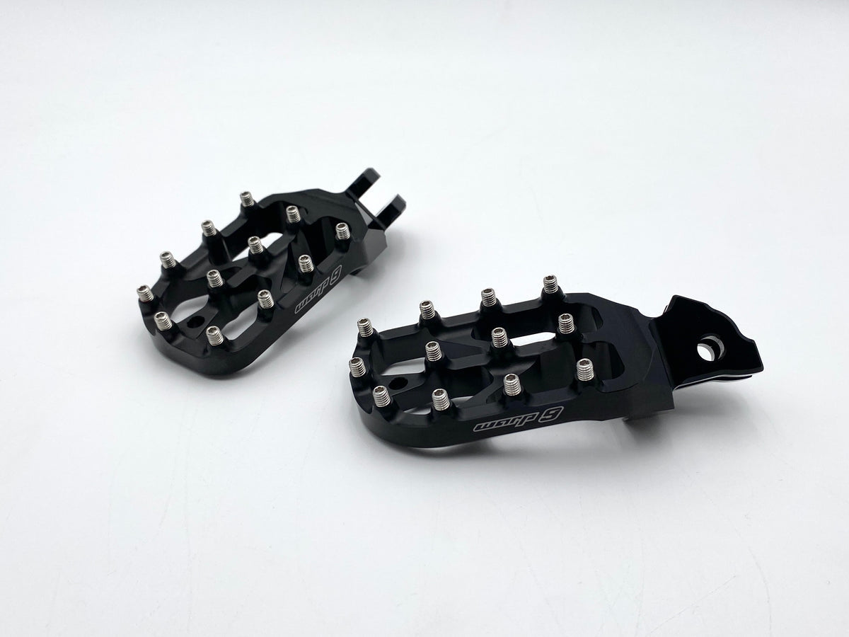 Black anodized Warp 9 Elite foot pegs with stainless teeth