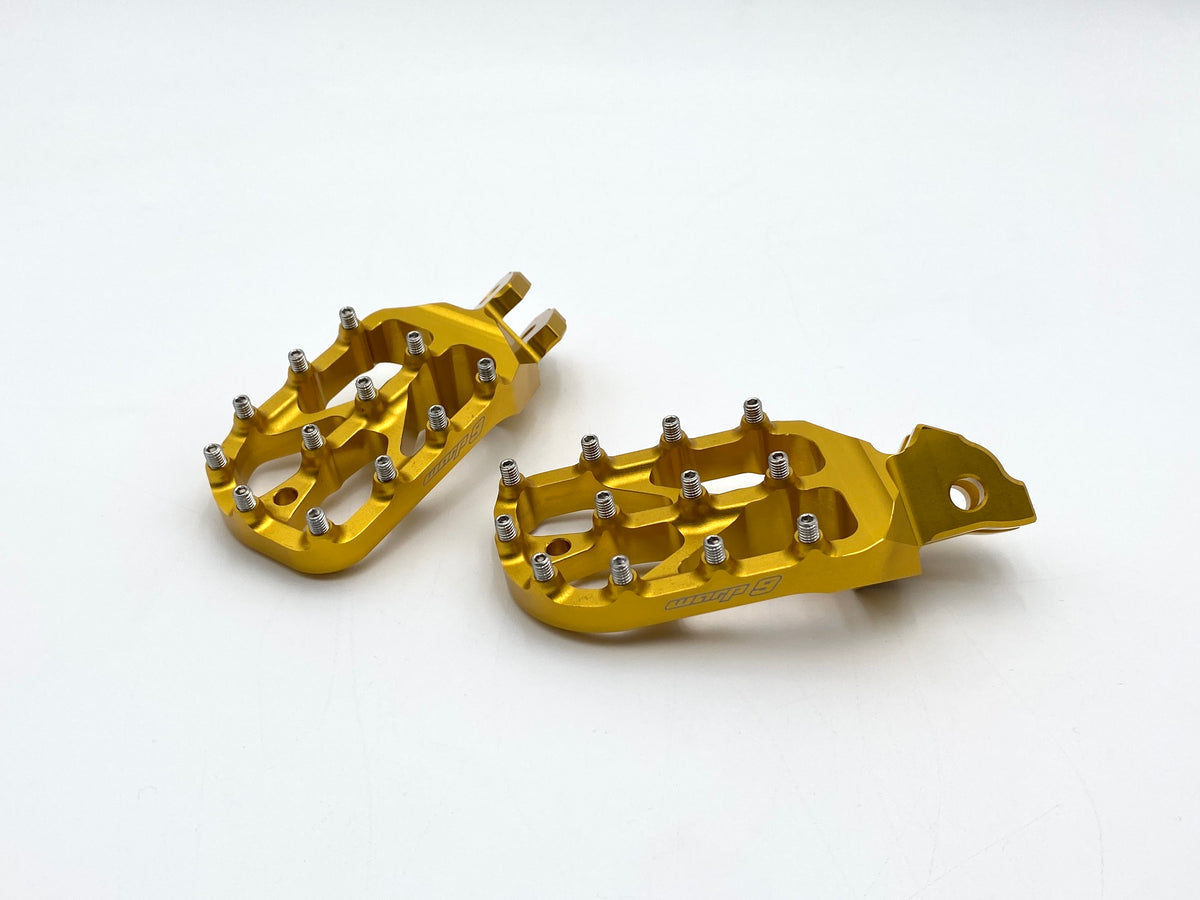 Gold anodized Warp 9 Elite foot pegs showing the 89 by 58mm platform