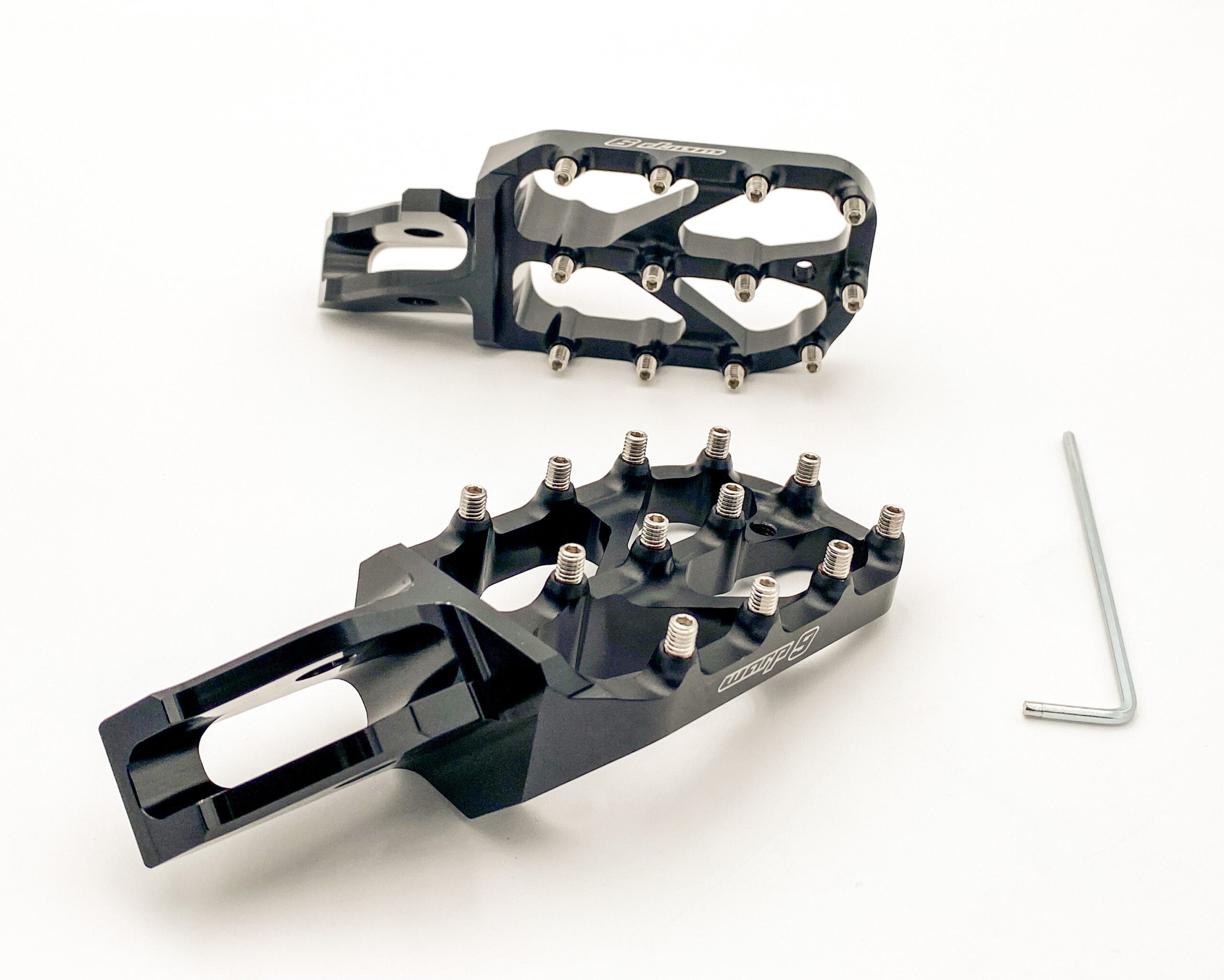 Black anodized Warp 9 Elite foot pegs for the Sur-Ron Ultra Bee